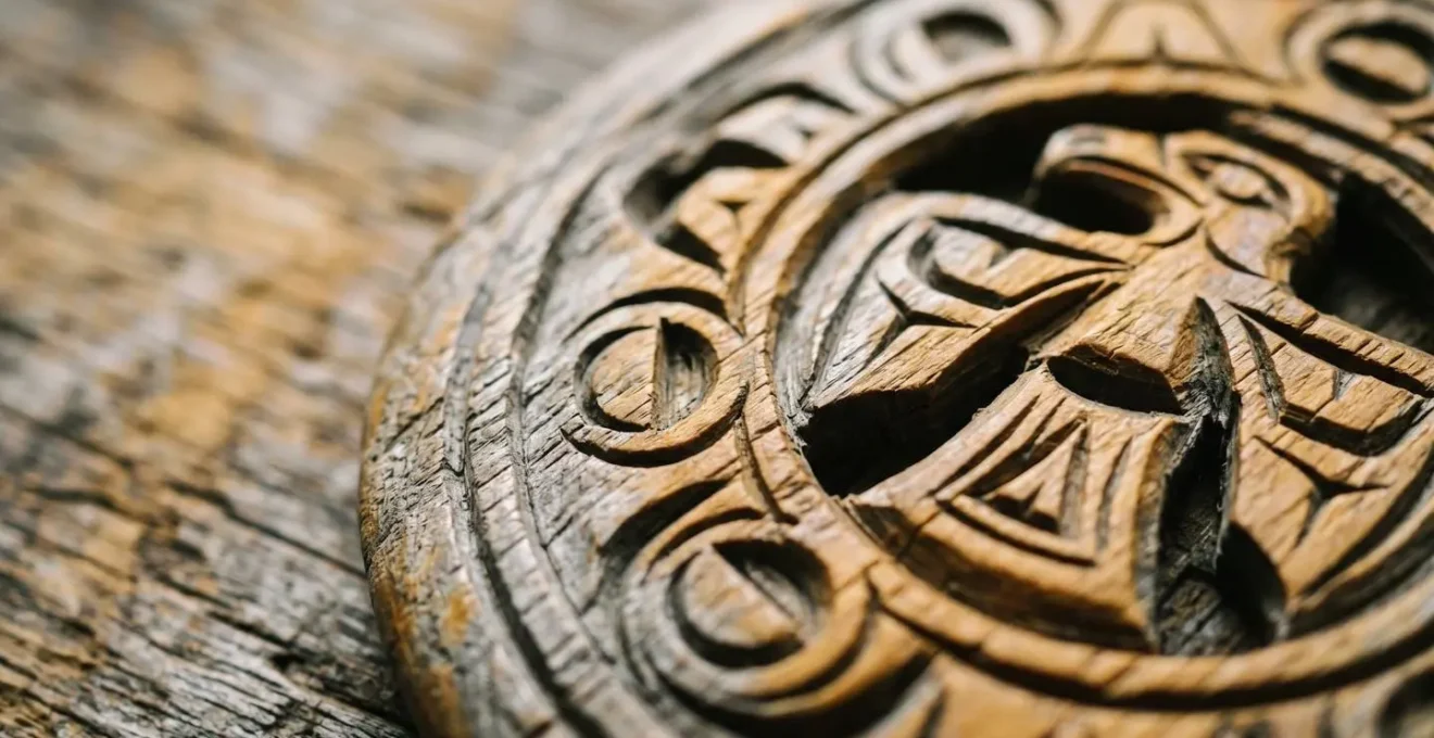 Close-up detail of Coast Salish spindle whorl carving in weathered cedar
