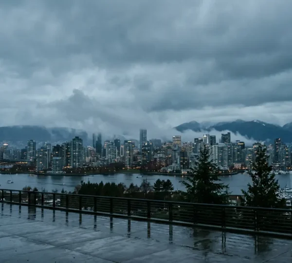 Moody Vancouver waterfront scene in November with rain-soaked streets reflecting city lights under overcast skies
