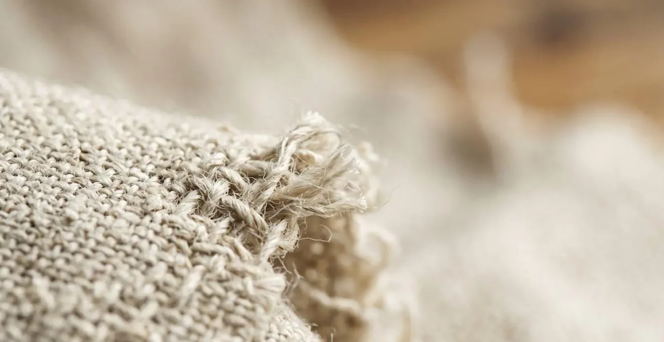 Close-up macro shot of organic linen fabric texture showing natural fibers and weave patterns